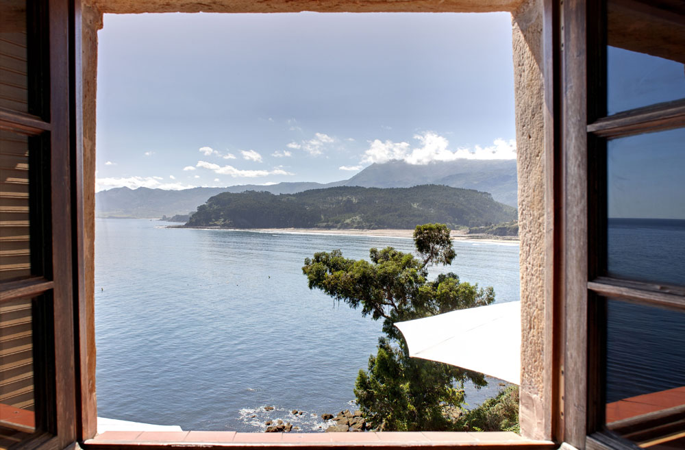 Vista a la playa desde la ventana de una habitación